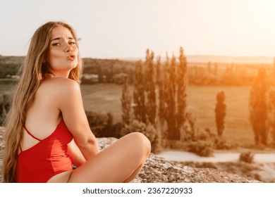 Well looking middle aged woman with long hair, fitness instructor in leggings and tops doing stretching and pilates on the rock near forest. Female fitness yoga routine concept. Healthy lifestyle - Shutterstock ID 2367220933