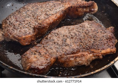 Well seasoned, rared outdoor beef steak cooking on a frying pan - Shutterstock ID 612771914