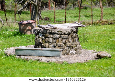 Οld well and watering can for animals