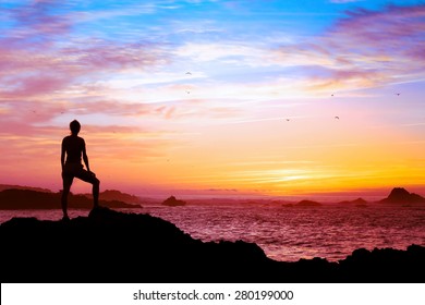 wellbeing concept, silhouette of person enjoying beautiful sunset with view of ocean 