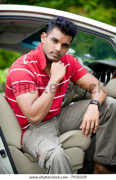 A
well-built Asian man in a saloon car in the
country
