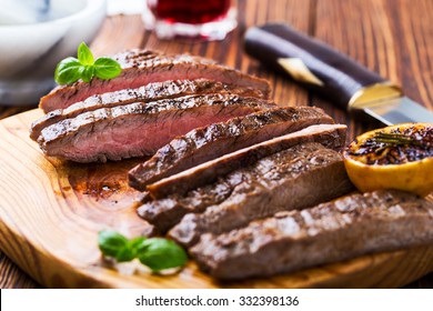 Well-done Grilled Marinated Beef Flank Steak On Wooden Board