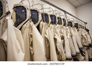 A welldressed man stands in a retail store, browsing a selection of suits and shirts. The stores interior features clothing racks, a window, and a clean. Elements of this image furnished by NASA - Powered by Shutterstock