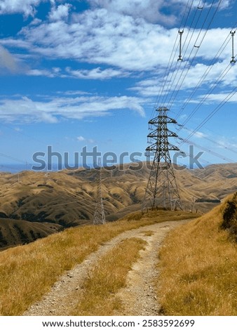 Similar – Foto Bild Windräder in hügeliger Landschaft mit Bäumen und abgeernteten Feldern / Frühherbst