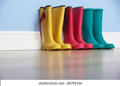 Wellingtons lines up against wall