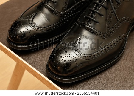 Well-maintained black full brogue leather shoes.