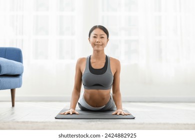 Wellness Attractive Asian woman practice yoga Cobra pose at home to meditation comfortable and relax,Calm of healthy young woman deep breath and meditation with yoga at home,Yoga Concept - Powered by Shutterstock