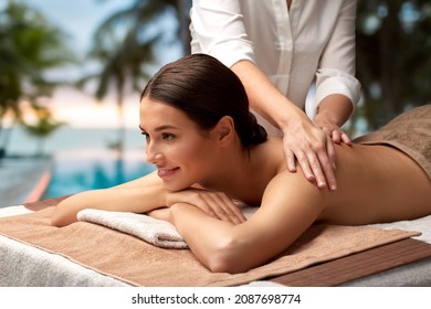 wellness, beauty and relaxation concept - beautiful young woman lying and having back massage at spa over tropical beach background in french polynesia - Powered by Shutterstock