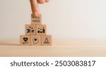 Wellness concept. Wooden cube blocks with health, mindfulness, mental health, happiness, financial stability and growth icons on white background. Balance, integration in achieving overall wellbeing.