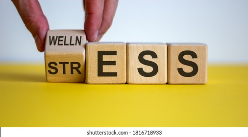 Wellness instead of stress. Hand turns a cube and changes the word 'stress' to 'wellness'. Beautiful yellow table, white background. Concept. Copy space. - Shutterstock ID 1816718933