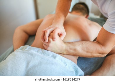 Wellness manual back massage for men. Relaxation of the lower back muscles by a male doctor in a private clinic. Photos for medical journals