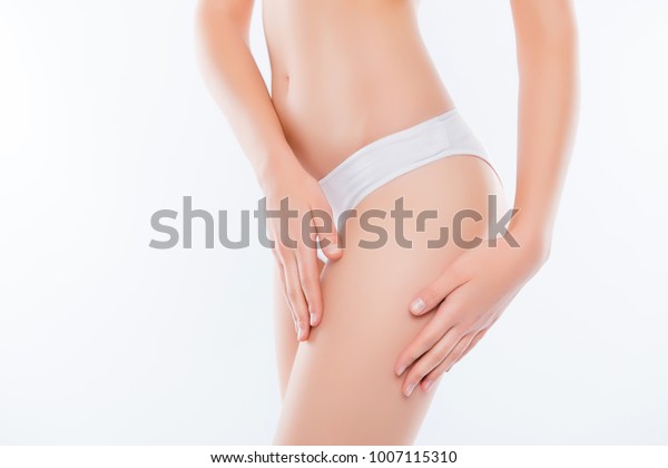 Wellness wellbeing purity freshness concept.\
Cropped close up photo of skinny slim slender attractive fit\
woman\'s thighs wearing white underpants gently touching soft fresh\
skin isolated on\
background