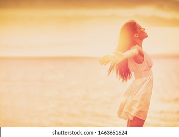 Wellness woman feeling free with open arms in freedom side profile silhouette on ocean beach background. Stress free happy emotion people.