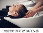 Wellness, woman or washing hair of customer in salon or basin for cleaning treatment and scalp. Rinse, hands and grooming service for client, person or shampoo cosmetics for beauty, health or spa