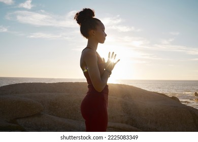 Wellness, yoga and meditation with black woman and fitness at the beach, calm and peace in the sun with lens flare. Zen, mindfulness and healthy mindset, athlete on rocks by the ocean for exercise. - Powered by Shutterstock