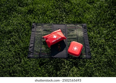 A wellorganized first aid kit is placed thoughtfully on a cozy blanket that is spread out over the lush green grass in a beautiful outdoor setting, ready for use if needed in case of emergencies - Powered by Shutterstock