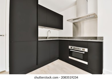 Well-organized interior of a small home kitchen with a black kitchen set - Shutterstock ID 2083519234
