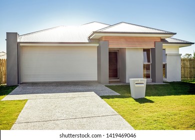 Well-planned House Exterior With A Garage, A Letter Box, Grass, And House Entrance