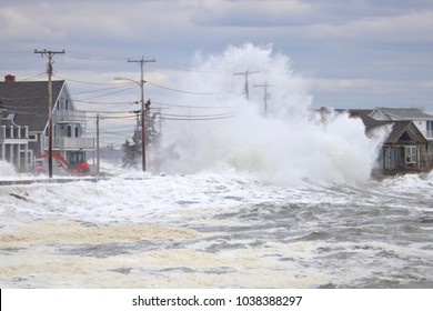 Wells, Maine, USA: February 3, 2018: A Storm Wave Crashes Over Two Telephone Poles And The Roof Of A Beach Front House In Wells Maine During High Tide Causing Massive Flooding.