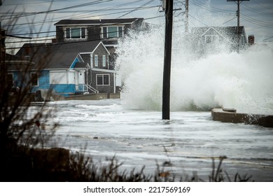 Wells, Maine, USA-October 20, 2020: Ocean Wave Crashes Over A Seawall Flooding The Road And Houses. Climate Change Is Causing More Coastal Flooding Concerns Alone The Maine Coast.