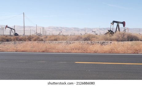 Wells With Pump Jacks On Oil Field, California USA. Rigs For Crude Fossil Extraction Working On Oilfield. Industrial Landscape, Derricks In Desert Valley. Many Pumpjacks Platforms On Oilwells Pumping.