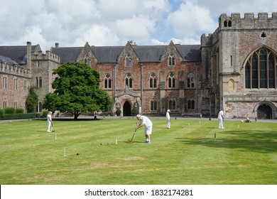 Wells, UK - August 20, 2020: People play croquet on a lawn court at the Bishop's Palace of the historic Wells Cathedral.