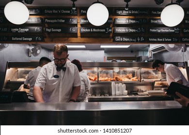 Wells-next-the-sea, UK - April 20, 2019: Staff serving fish and chips inside popular French's fish and chip shop in Wells-next-the-sea, a seaside town and port in Norfolk, UK, famous for its beach.