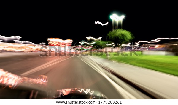 Wendover, Utah driving point of view in Nevada\
city hotels and casinos on road at night illuminated neon light\
trails abstract blurred motion\
background
