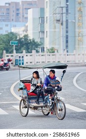 WENZHOU-NOV., 2014. Cycle rickshaw. It is a small-scale local transport mode also known by a variety of names such as bike taxi, velotaxi, pedicab, bike-cab, cyclo, beca, becak, trisikad, or trishaw.