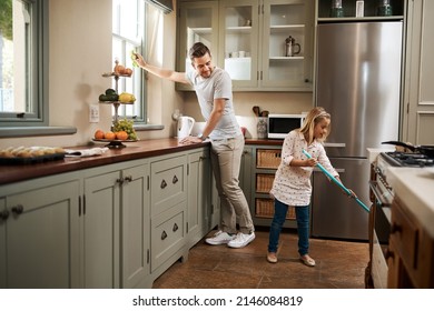 Were Giving Mom The Day Off. Shot Of A Young Man And His Daughter Cleaning The Kitchen At Home.