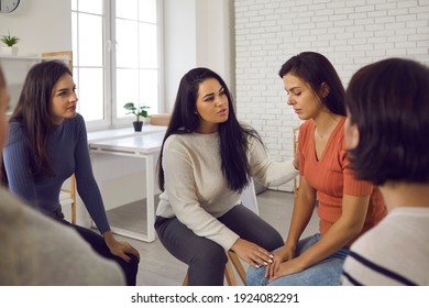 We're Here To Help You. Women In Support Group Meeting Or Therapy Session Showing Solidarity, Talking To And Comforting Depressed Young Woman Who's Suffered From Emotional Abuse And Domestic Violence