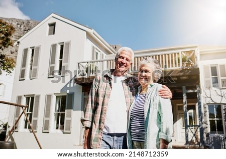 Were living the retirement dream. Shot of a happy senior couple standing together in front of their house.