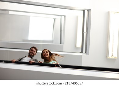 Were making our way to the top. Shot of two people in stairwell smiling while looking down at you.