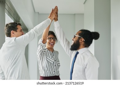 Were an unstoppable team. Shot of a group of businesspeople high fiving together in an office.