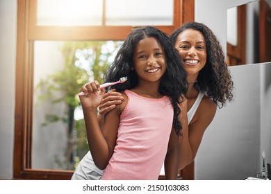 Were wearing matching smiles today. Cropped portrait of an attractive young woman and her daughter brushing their teeth in the bathroom at home. - Powered by Shutterstock