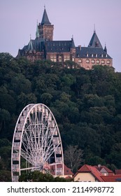Wernigerode Castle in the evening with a Ferris wheel in the foreground