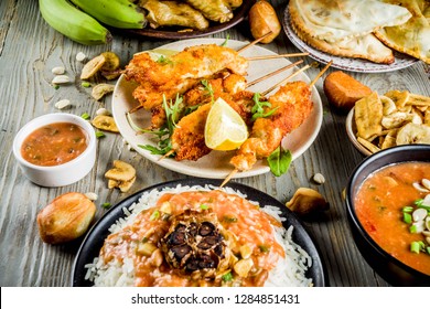 West African Food Concept. Traditional Wset African Dishes Assortment - Peanut Soup, Jollof Rice, Grilled Chicken Wings, Dry Fried Bananas Plantains, Nigerian Chicken Kebabs, Meat Pies, Top View