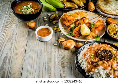 West African Food Concept. Traditional Wset African Dishes Assortment - Peanut Soup, Jollof Rice, Grilled Chicken Wings, Dry Fried Bananas Plantains, Nigerian Chicken Kebabs, Meat Pies, Top View