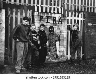 West Belfast, Northern Ireland, UK,or March, 1994, Beechmont Estate Neighborhood Kids Pose Next To Street Mural Honoring Armed Members Of The Provisional Irish Republican Army (PIRA)