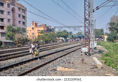 West Bengal, 02-13-2022: Two young girls are walking across train lines instead of using railway foot bridge (this type of carelessness and absent-mindedness often causes accident).