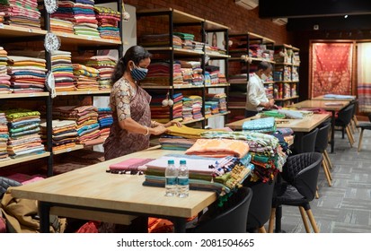 West Bengal, 09-08-2021: Store Workers (wearing Face Mask) Busy Inside A Well Decorated Retail Fabric Store At Phulia, Famous For Handloom Sarees From Ancient Times.