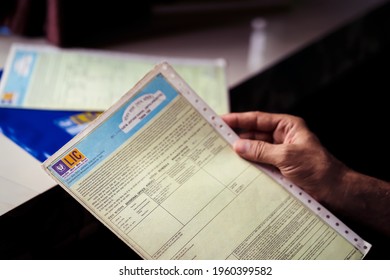 West Bengal, India, January 28, 2021 : A Man Or LIC Policy Holder Looking At His Life Insurance Papers And Premium. Concept For LIC IPO, Privatization Of Government Companies.