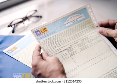 West Bengal, India, January 28, 2021 : A Man Or LIC Policy Holder Looking At His Life Insurance Papers And Premium. Concept For LIC IPO, Privatization Of Government Companies.