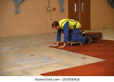 WEST COAST, NEW ZEALAND, JUNE 28, 2019: A Tradesman Lays New Carpet Squares In A Commercial Building.