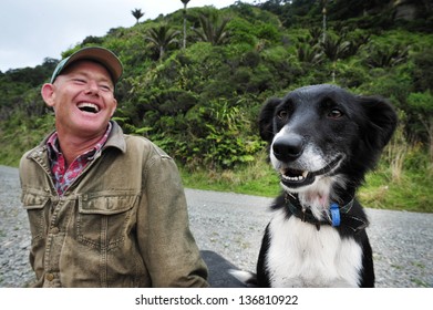 
WEST COAST, NZ - APR 19 2009:Happy New Zealand Farmer Laughing With Border Collie Herding Dog In A Sheep Farm.Border Collie Are Very Intelligence Bred Developed In Scotland For Herding Livestock.


