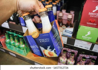 West Covina, California, United States - 02-19-2020: A Hand Holds A Case Of Myx Moscato And Peach Wine Beverage On Display At A Local Grocery Store.