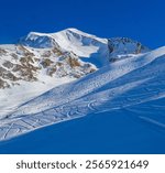 West Face of Mont Charvin in Winter with Powder Ski Tracks and Blue Sky