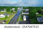 West Gentry Avenue in downtown Checotah, small town in McIntosh County, Oklahoma, mix of commercial buildings, churches, schools, residential neighborhood large houses, lush green trees, aerial. USA