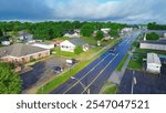 West Gentry Avenue in downtown Checotah, small town in McIntosh County, Oklahoma, mix of commercial buildings, churches, schools, residential neighborhood large houses, lush green trees, aerial. USA