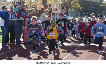 West Islip, NY, USA - 24 November 2017: The Start Of The Kids Fun Run On A Red Track With Their Parents Cheering Them On At A Local Turkey Trot Race On Thanksgiving Weekend.